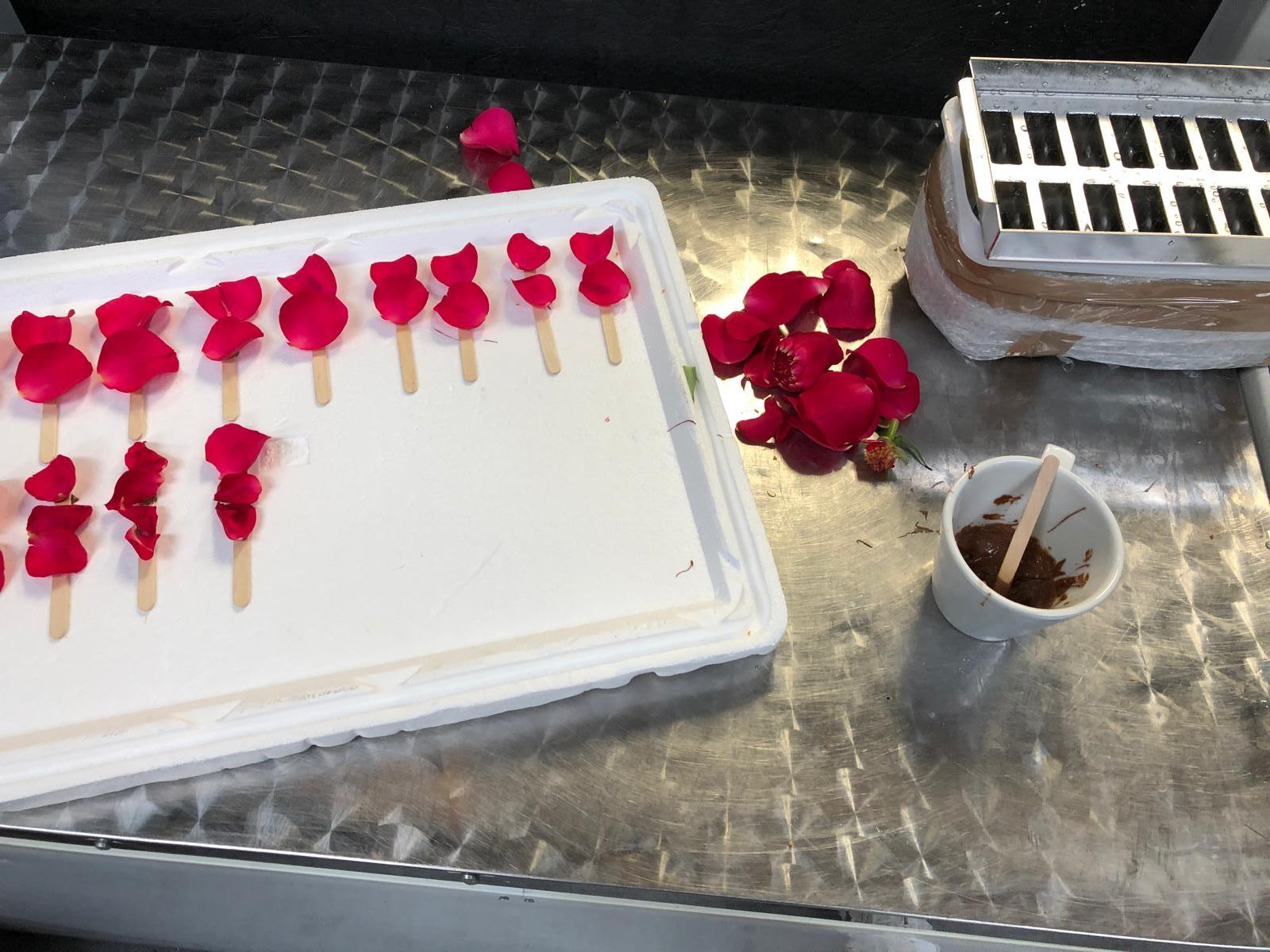 Handcrafted assembly of rose petals and sticks on prep bench