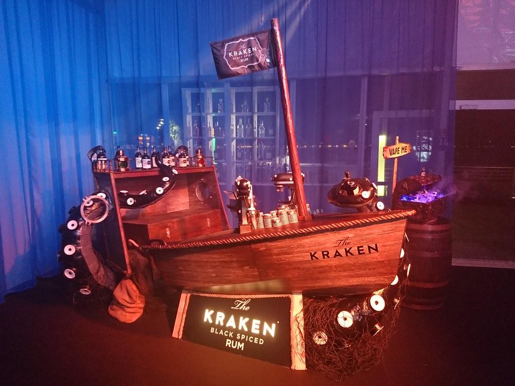 Kraken Black Spiced Rum pirate ship bar at indoor corporate gala with glowing signage and fog