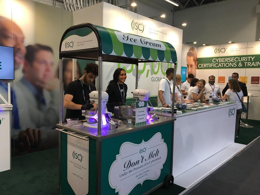 ISC2 cybersecurity exhibition booth featuring branded ice cream cart with engaged attendees