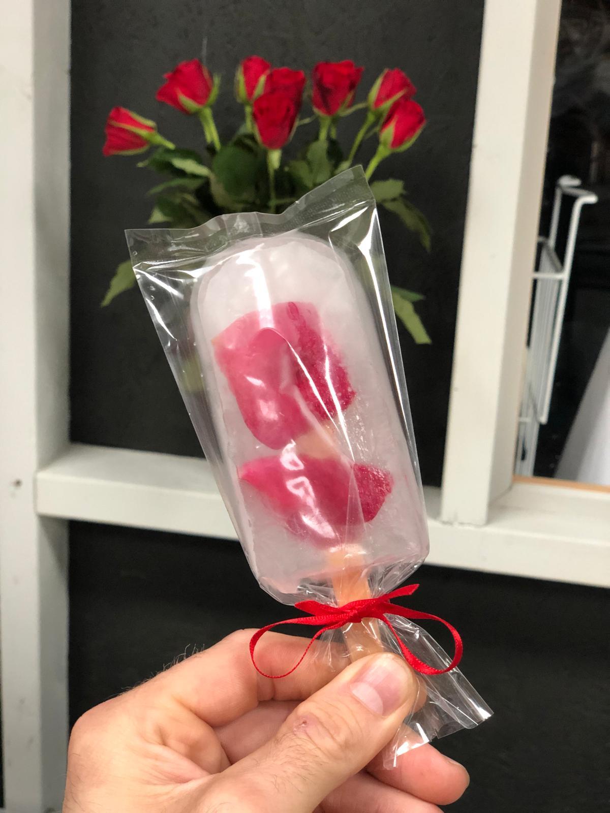 Bespoke perfumed ice lolly with edible rose petals and red ribbon tie created for KENZO