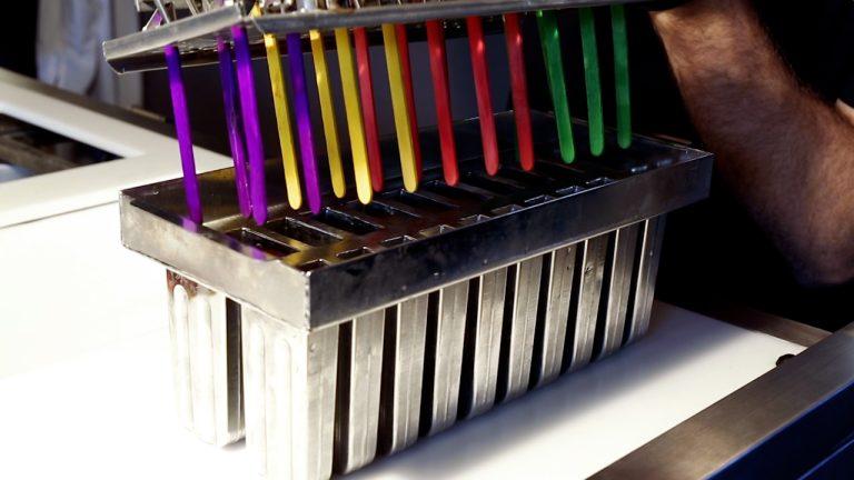 Stainless steel ice lolly moulds with colourful branded sticks ready for flash freezing