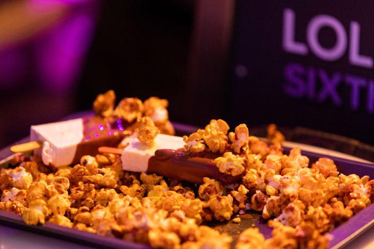 Freshly dipped chocolate ice lollies with warm caramel popcorn topping at Lolly Lab event