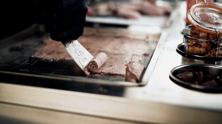 Chef rolling delicate ice cream curls with spatula