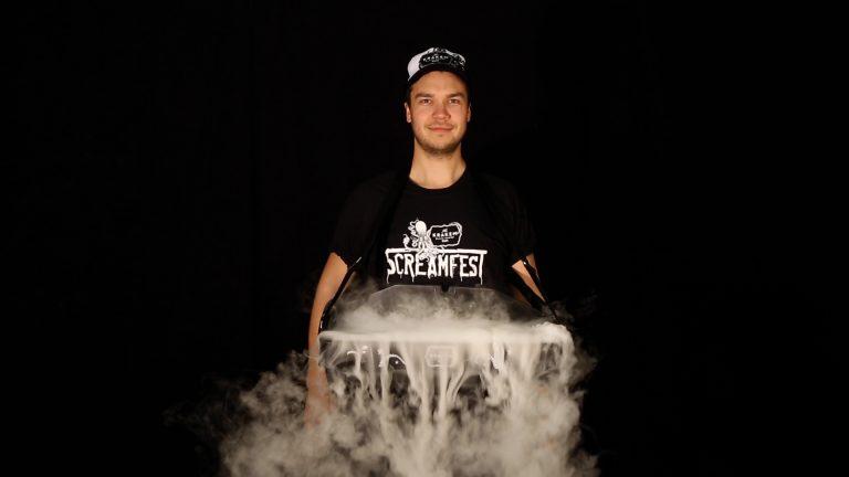 Host carrying The Misty Tray illuminated with billowing theatrical mist