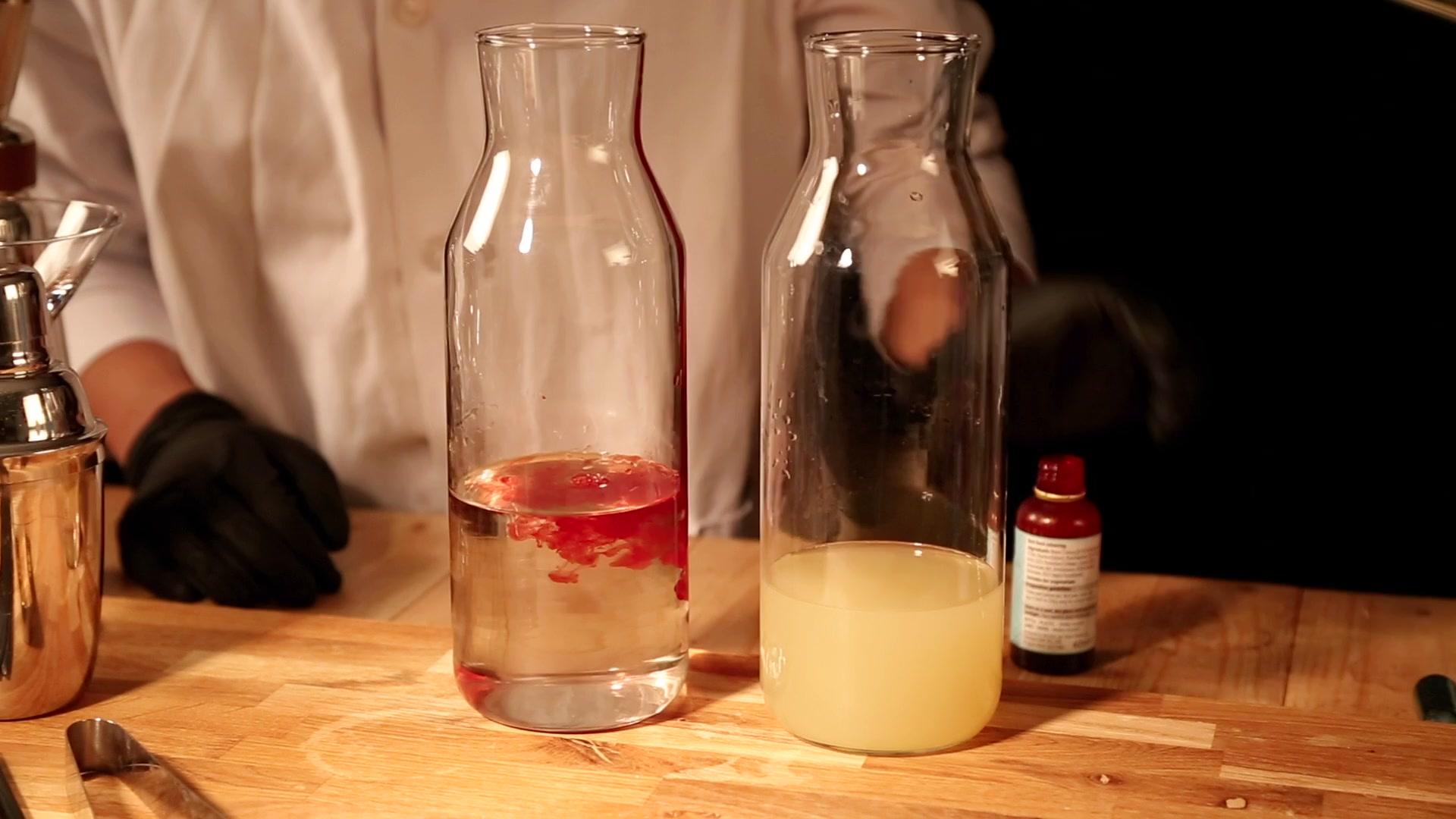 Theatrical colour-changing botanical cocktail infusion reacting and shifting hues inside carafe