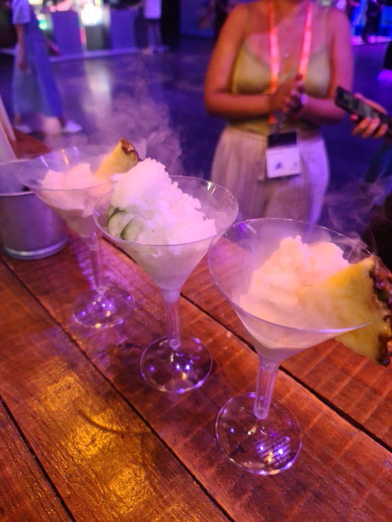Smoking frozen martini sorbets garnished with fresh pineapple and cucumber