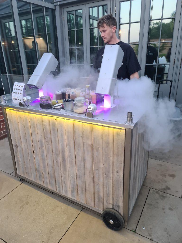 Twin-mixer mobile liquid nitrogen ice cream cart outside wedding venue with purple LED underglow and cryogenic fog